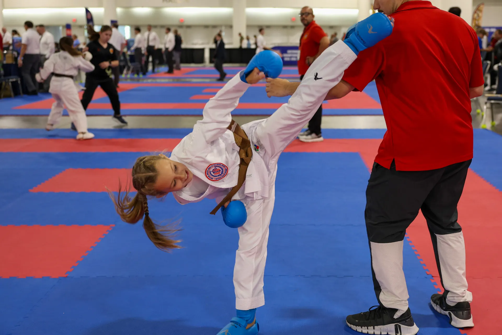 Dominika Tsybina landing a high karate kick during a kumite match